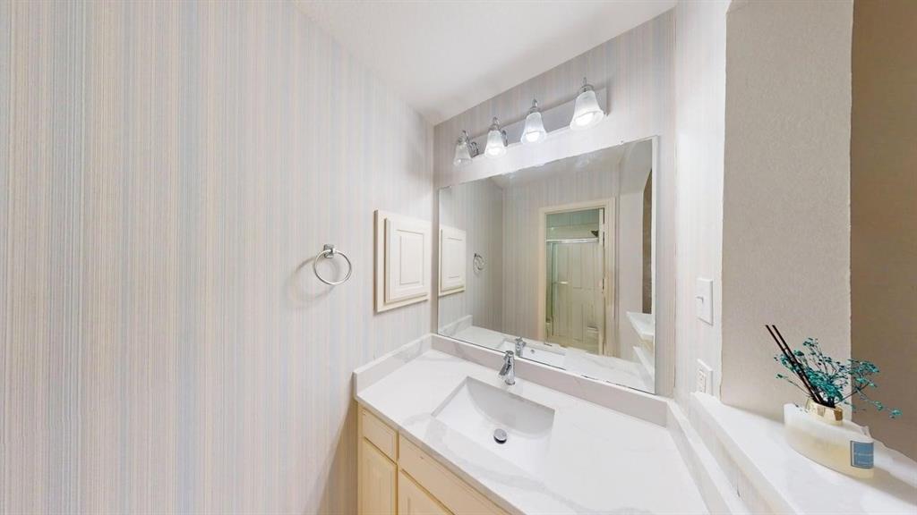 2022 Huntcliffe Court Allen, TX 75013 - Photo 34 of 40 Bathroom featuring a shower stall, vanity, and wallpapered walls