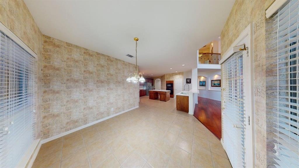 2022 Huntcliffe Court Allen, TX 75013 - Photo 40 of 40 Kitchen featuring light countertops, open floor plan, suspended lighting, wallpapered walls, and light tile patterned flooring