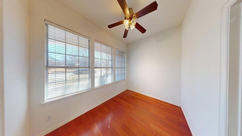 2022 Huntcliffe Court Allen, TX 75013 - Photo 7 of 40 Unfurnished living room featuring dark wood-style floors, a glass covered fireplace, a high ceiling, a ceiling fan, and suspended lighting