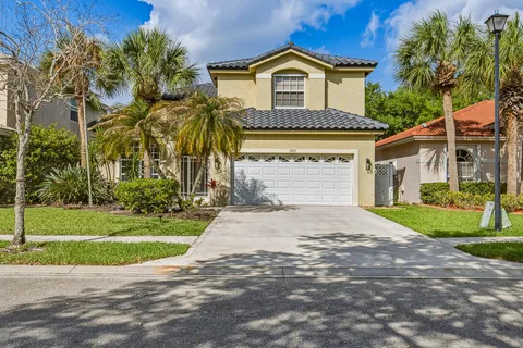 a kitchen with stainless steel appliances granite countertop a kitchen island a stove a sink a dining table and chairs with wooden floor