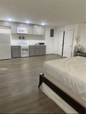 a view of a kitchen with white cabinets and a refrigerator