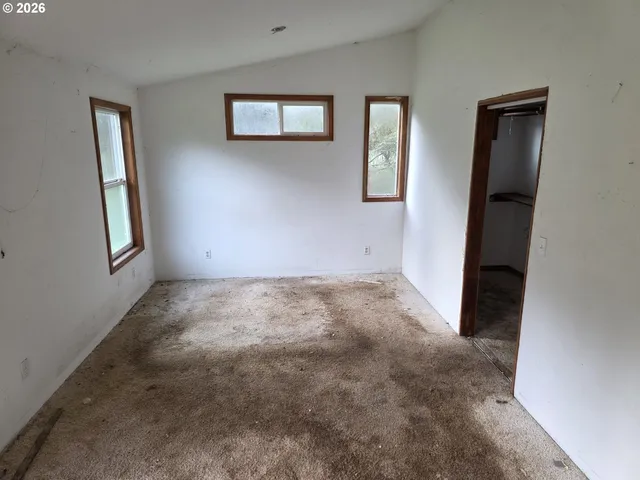 an empty room with windows and closet
