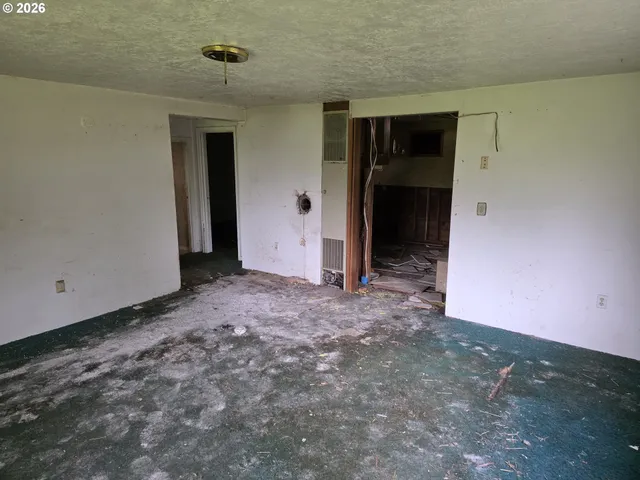 a utility room with stainless steel appliances wooden cabinets a sink and a window