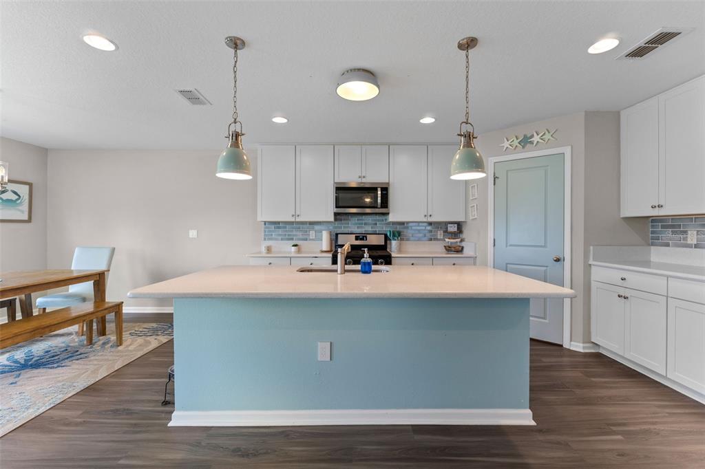 562 Meadow Ridge Drive St. Augustine, FL 32092 - Photo 15 of 61 a large kitchen with kitchen island a stove a sink a center island and wooden floor