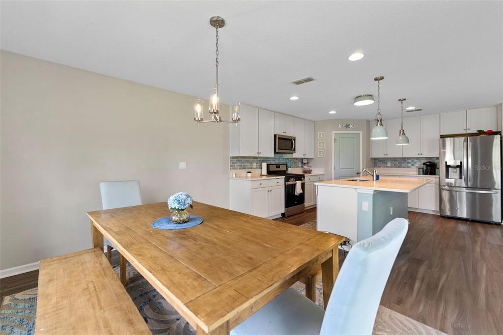 562 Meadow Ridge Drive St. Augustine, FL 32092 - Photo 19 of 61 a kitchen with sink a refrigerator and chairs