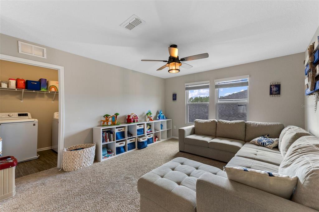 562 Meadow Ridge Drive St. Augustine, FL 32092 - Photo 27 of 61 a living room with furniture and a book shelf