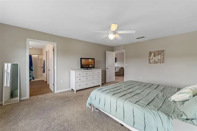 a bedroom with a bed and a chandelier fan