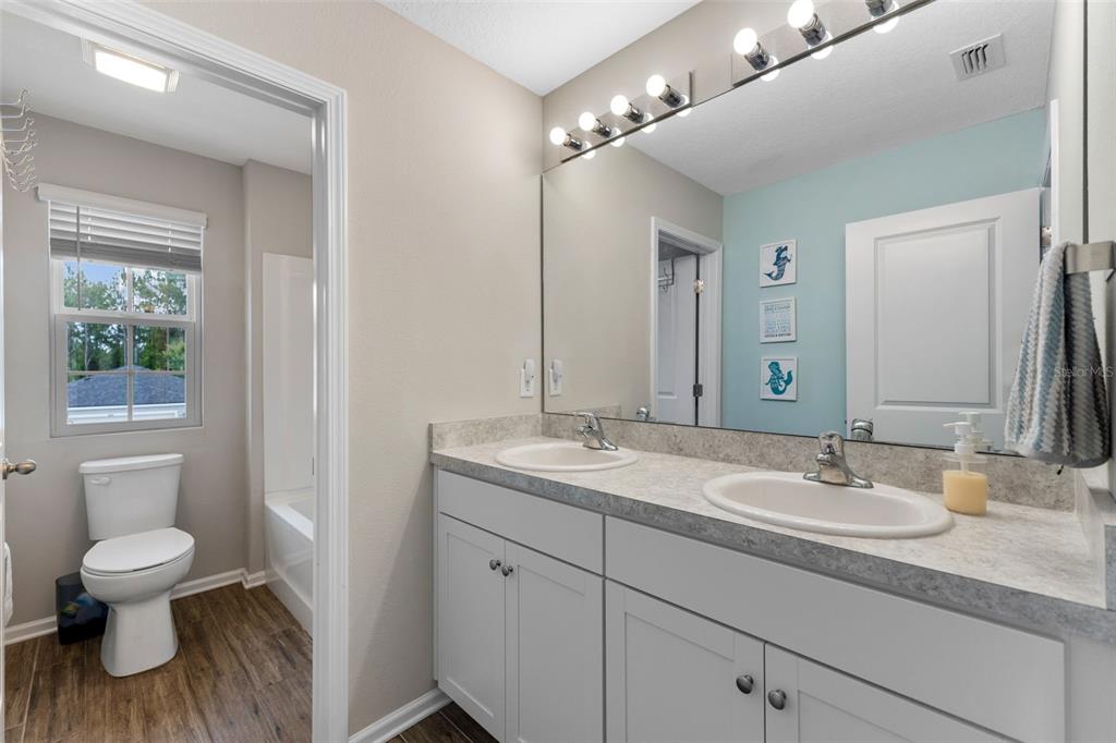 562 Meadow Ridge Drive St. Augustine, FL 32092 - Photo 37 of 61 a bathroom with a granite countertop sink a toilet and a mirror