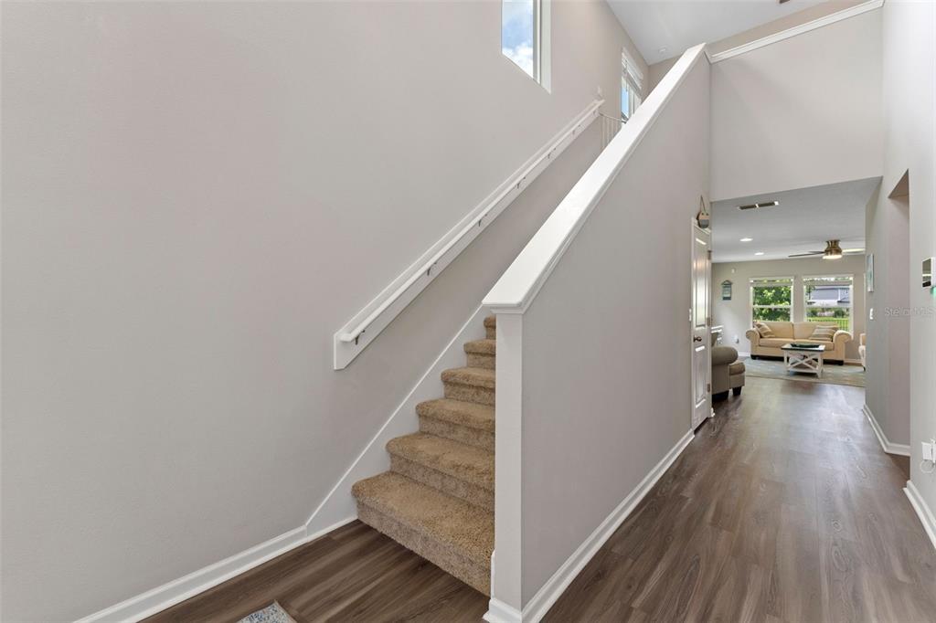 562 Meadow Ridge Drive St. Augustine, FL 32092 - Photo 8 of 61 a view of a hallway view with wooden floor and staircase