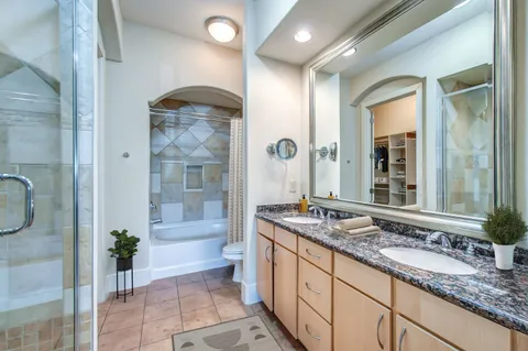 a bathroom with a granite countertop sink mirror and bathtub