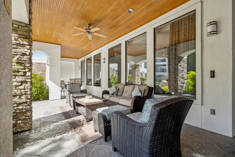 a view of a patio with a table and chairs next to a large window