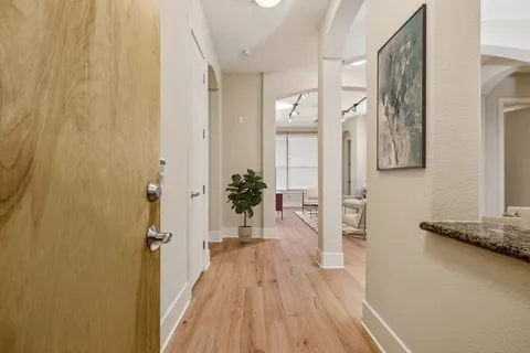 a view of a hallway with wooden floor and staircase
