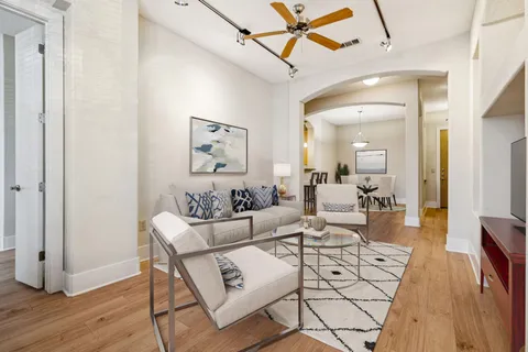 a living room with furniture and a wooden floor