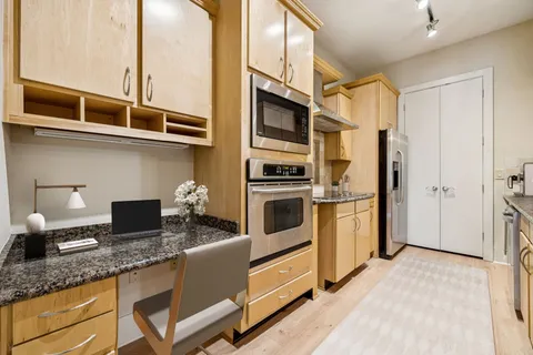 a kitchen with stainless steel appliances granite countertop a refrigerator and a stove top oven