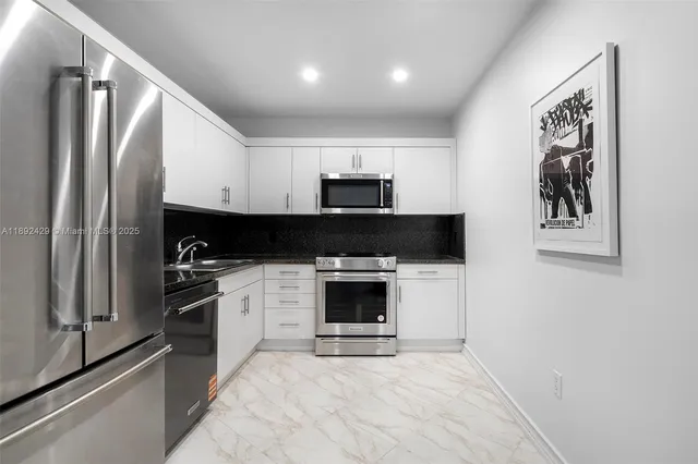 a kitchen with stainless steel appliances granite countertop a stove top oven and sink