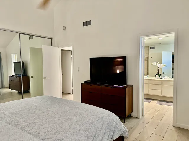 a bedroom with a bed and a flat screen television