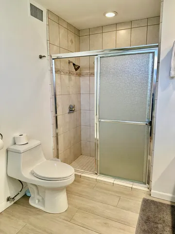 a bathroom with a toilet and a shower