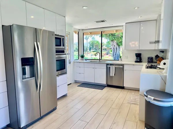 a kitchen with stainless steel appliances a refrigerator sink and microwave