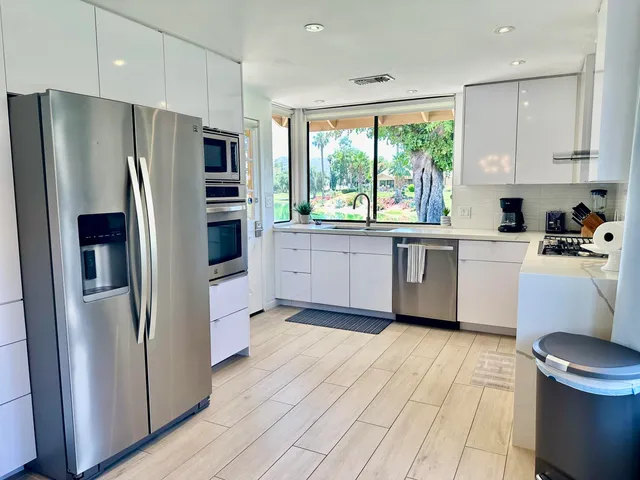 a kitchen with stainless steel appliances a refrigerator sink and microwave