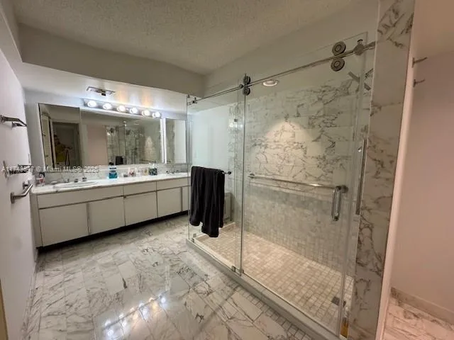 a bathroom with a double vanity sink mirror and shower