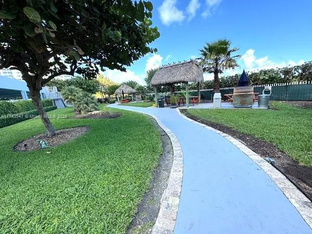 a view of a garden with a table and chairs under an umbrella