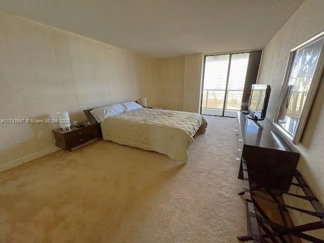 a spacious bedroom with a bed and wooden floor