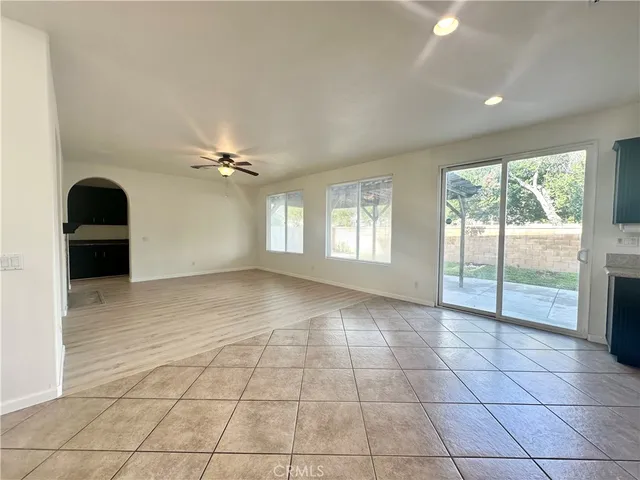 a view of an empty room with wooden floor and stairs