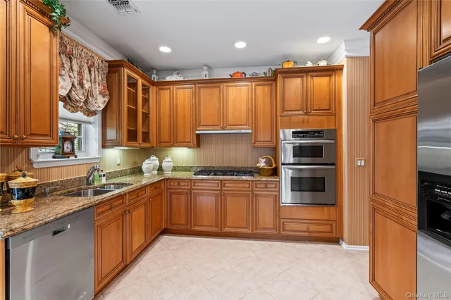 a kitchen with stainless steel appliances granite countertop a stove a sink and a refrigerator
