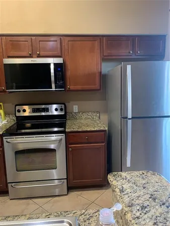 a kitchen with stainless steel appliances granite countertop a refrigerator stove and microwave