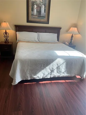 a view of bedroom with bed and wooden floor