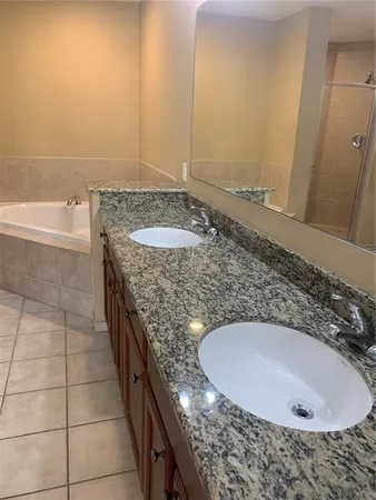 a bathroom with a granite countertop sink and mirror