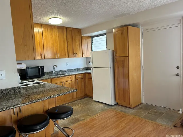 a kitchen with a refrigerator a stove a sink and a cabinets
