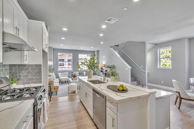 a kitchen that has a lot of cabinets a sink and wooden floor