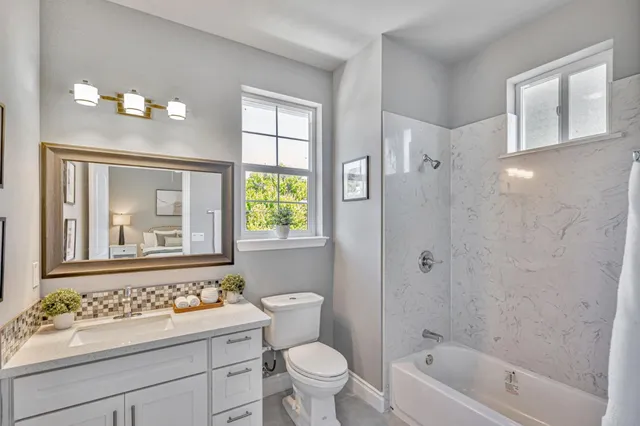 a bathroom with a sink a toilet a shower a mirror and a bathtub