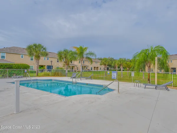 a dining room with furniture and large windows