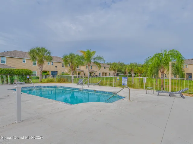 a dining room with furniture and large windows