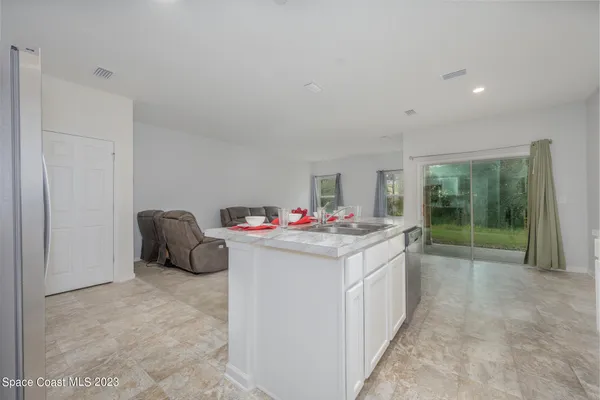 a kitchen with white cabinets and black appliances