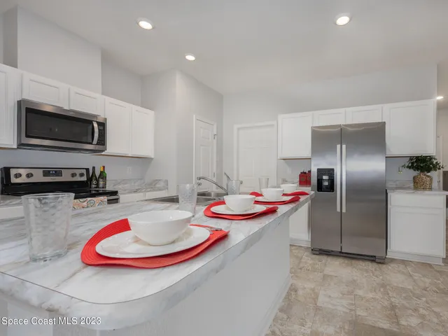 a kitchen with stainless steel appliances granite countertop a refrigerator and a stove top oven