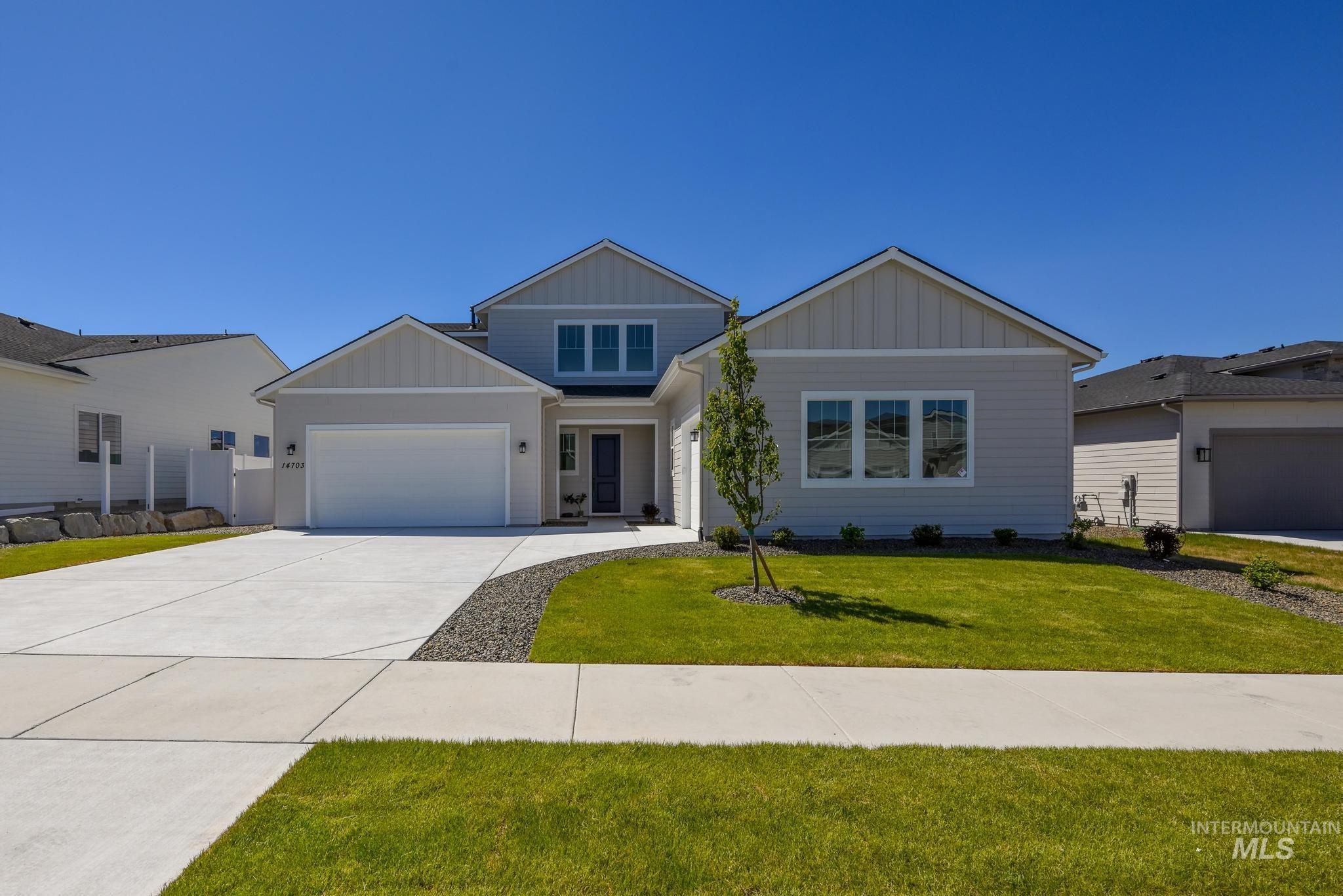 Light gray siding exterior with white trim and a contrasting dark entry door