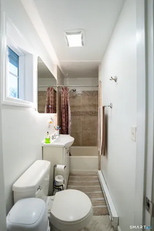 a white toilet sitting next to a bathroom sink and a shower