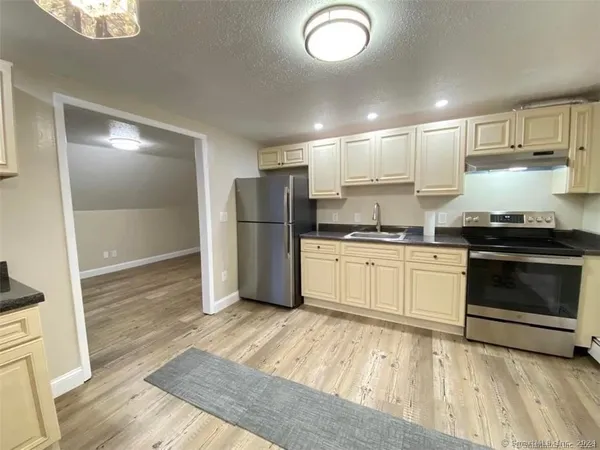 a kitchen with a refrigerator and white cabinets