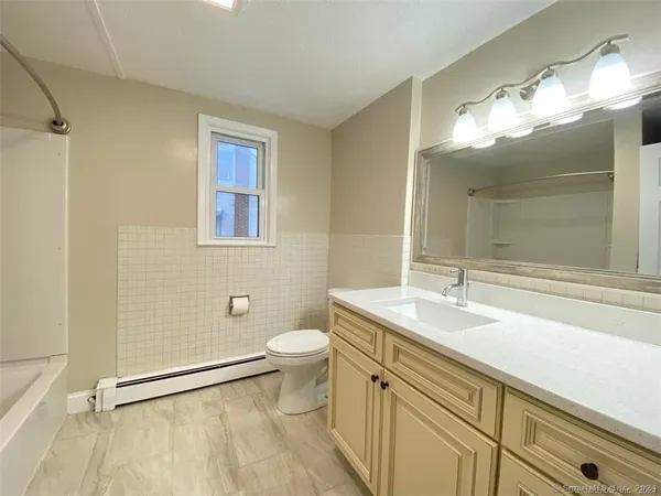 a bathroom with a sink vanity granite and toilet