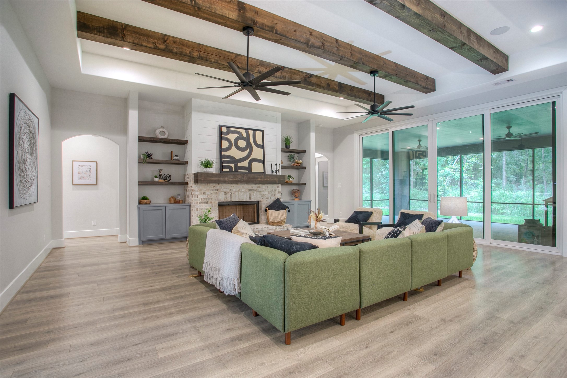 12915 Oak Barrel Road Willis, TX 77378 - Photo 8 of 46 This spacious family room features modern design with exposed wooden beams, a lovely fireplace, and large sliding glass doors that open to a scenic view.
