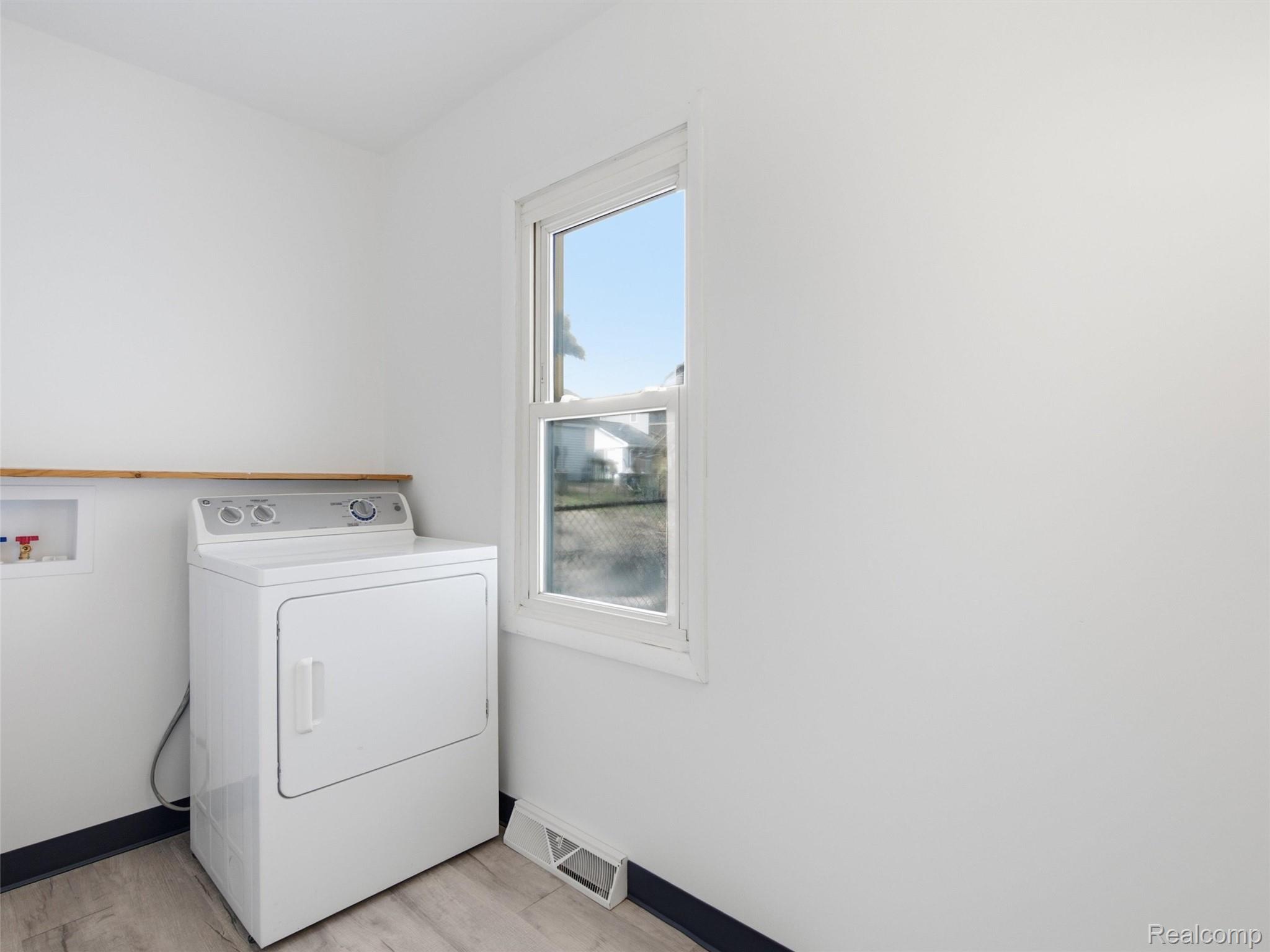 808 Corwin Court Pontiac, MI 48340 - Photo 26 of 34 Utility space featuring light wood-finish flooring, a single window, and a built-in wood shelf used for your laundry needs