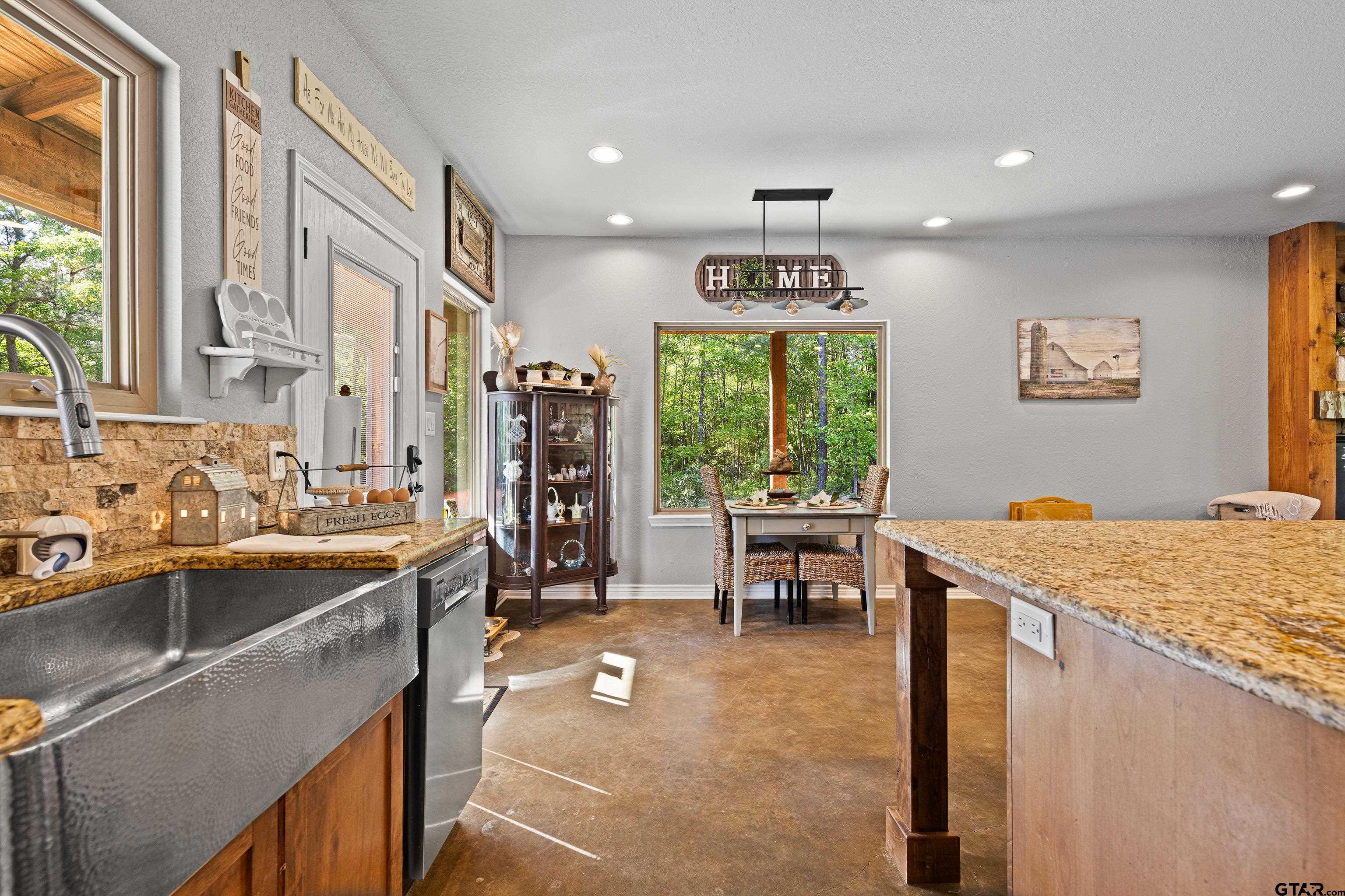 10586 Petunia Road Ore City, TX 75683 - Photo 17 of 45 a kitchen with stainless steel appliances granite countertop sink stove and table