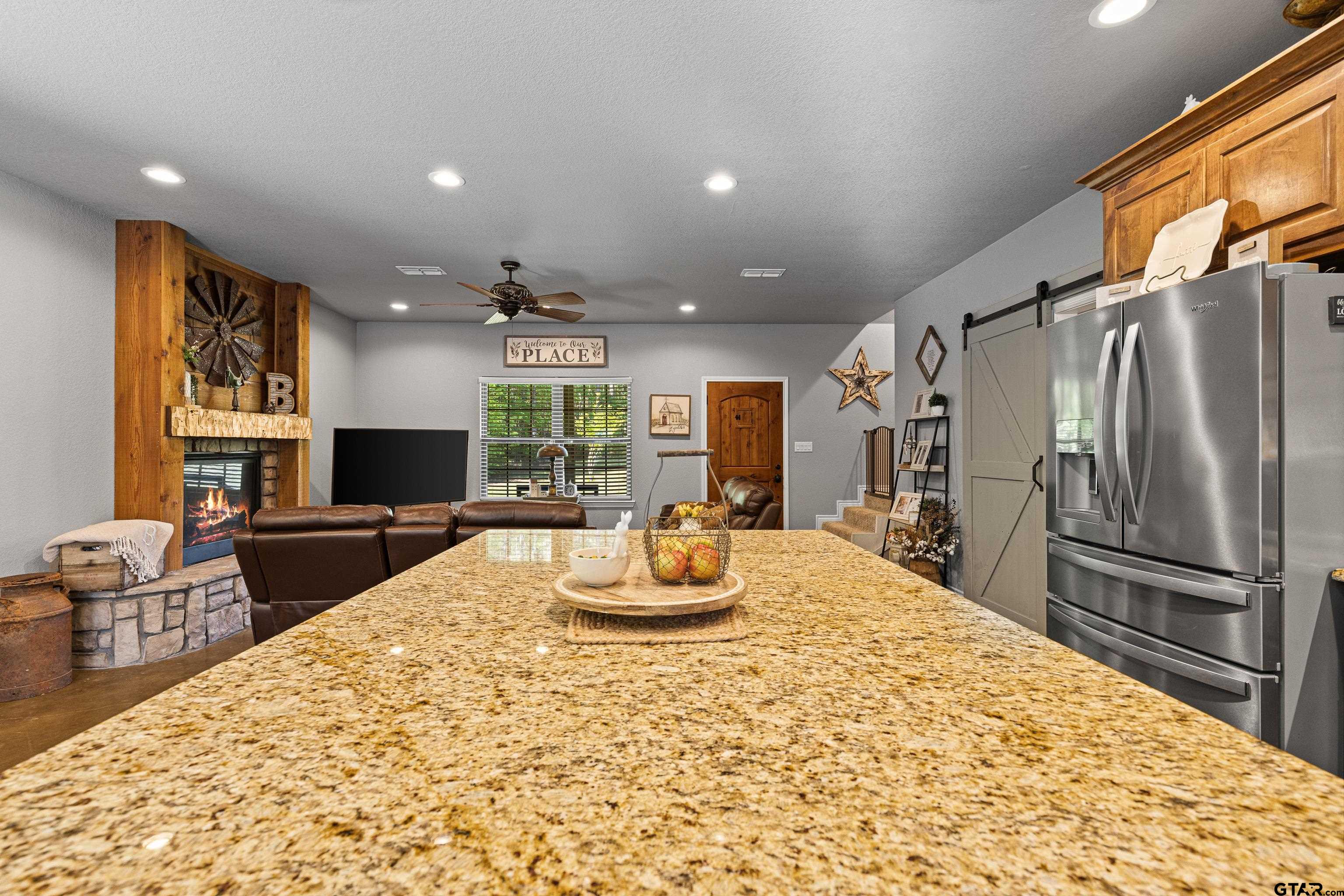 10586 Petunia Road Ore City, TX 75683 - Photo 18 of 45 a kitchen with stainless steel appliances kitchen island granite countertop a refrigerator and microwave