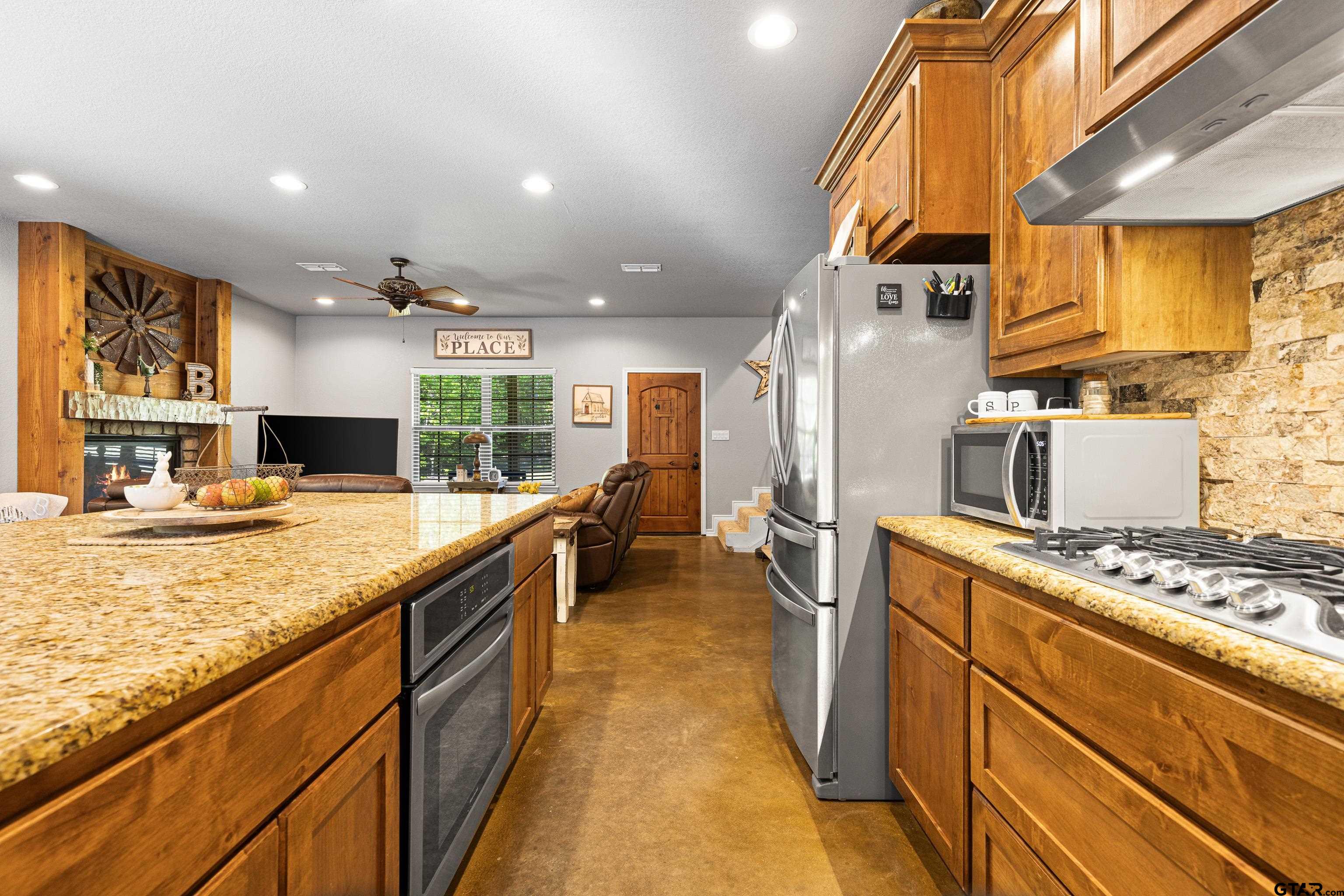 10586 Petunia Road Ore City, TX 75683 - Photo 19 of 45 a kitchen with stainless steel appliances granite countertop a sink stove and refrigerator