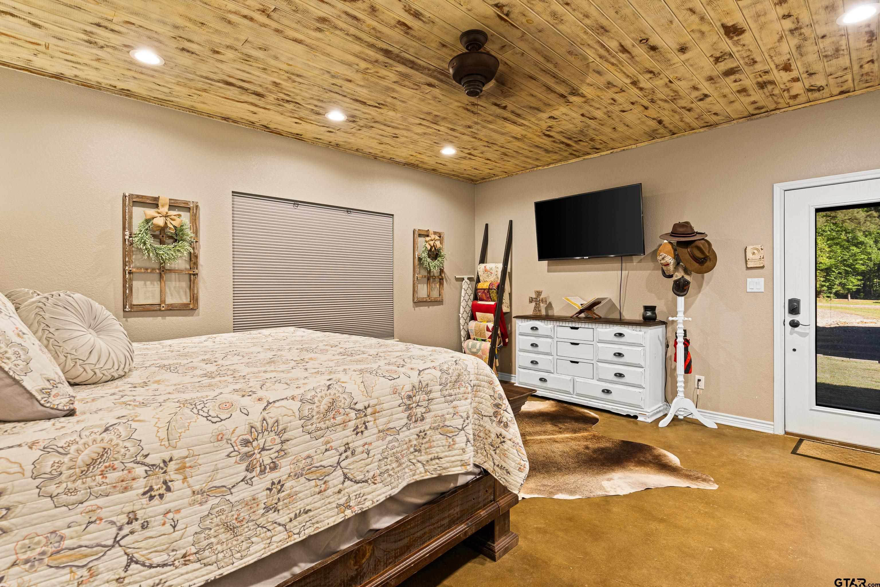 10586 Petunia Road Ore City, TX 75683 - Photo 25 of 45 a bedroom with a bed and a flat screen tv