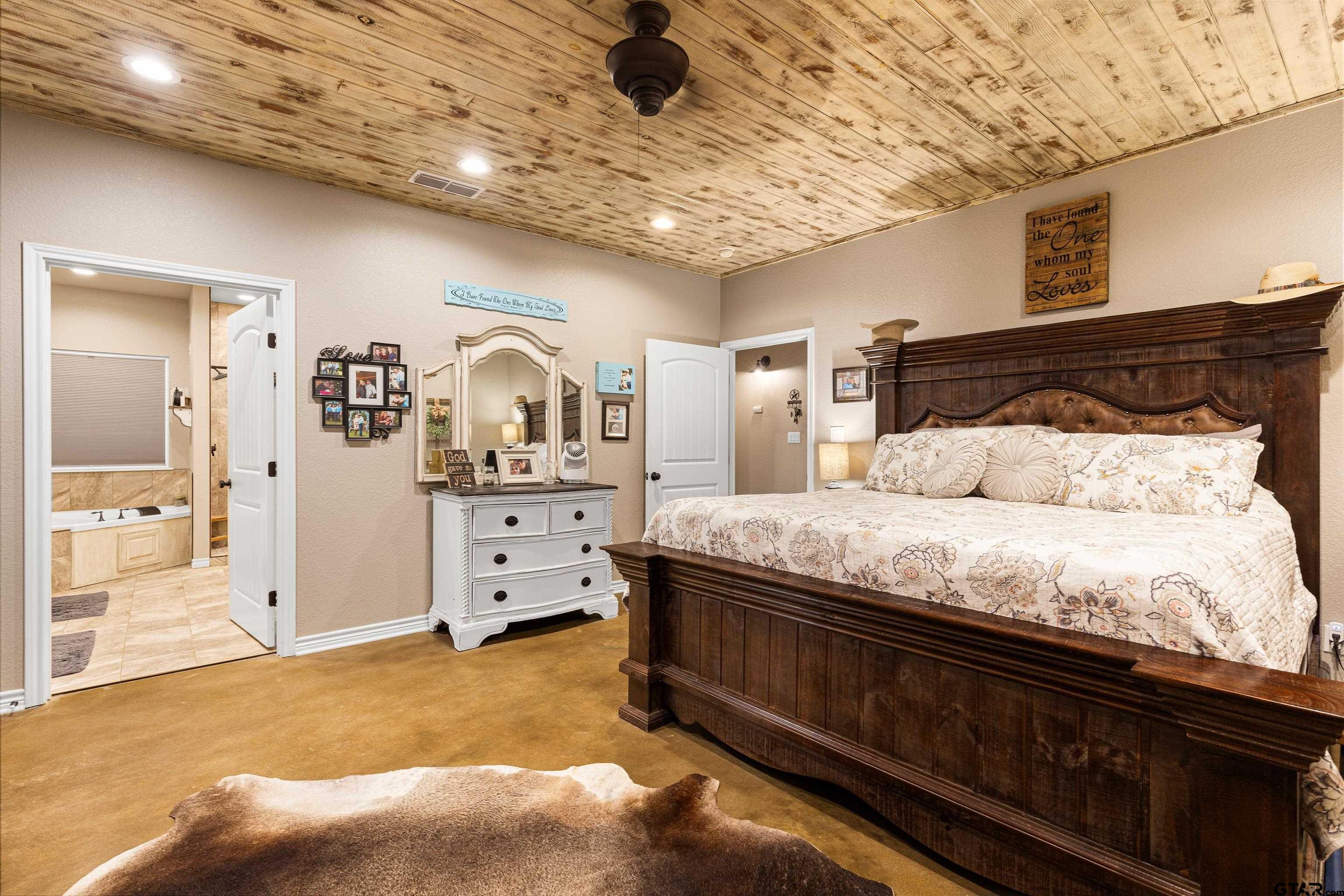 10586 Petunia Road Ore City, TX 75683 - Photo 26 of 45 a spacious bedroom with a bed and a walk in closet