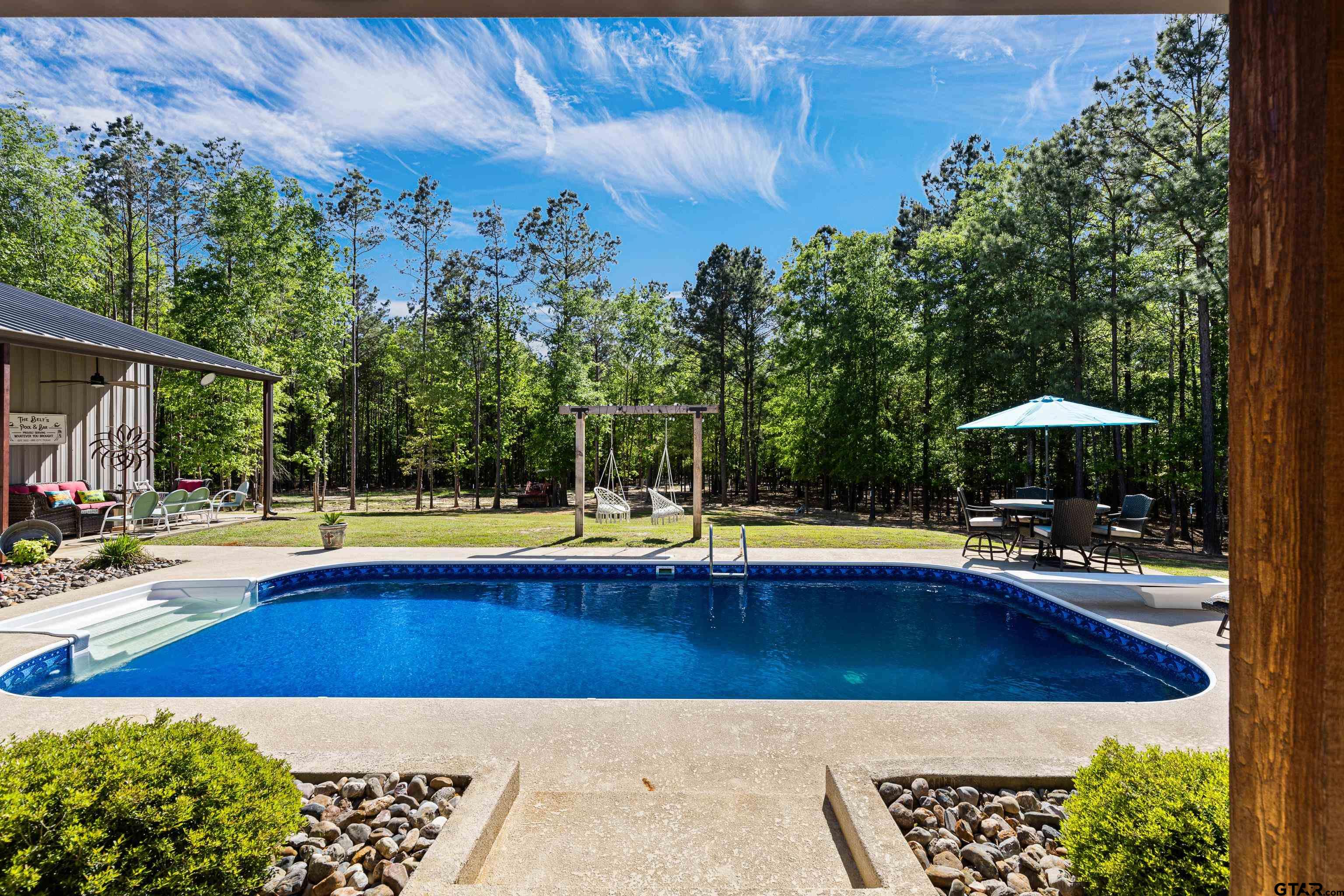 10586 Petunia Road Ore City, TX 75683 - Photo 10 of 45 a view of a swimming pool and lounge chairs